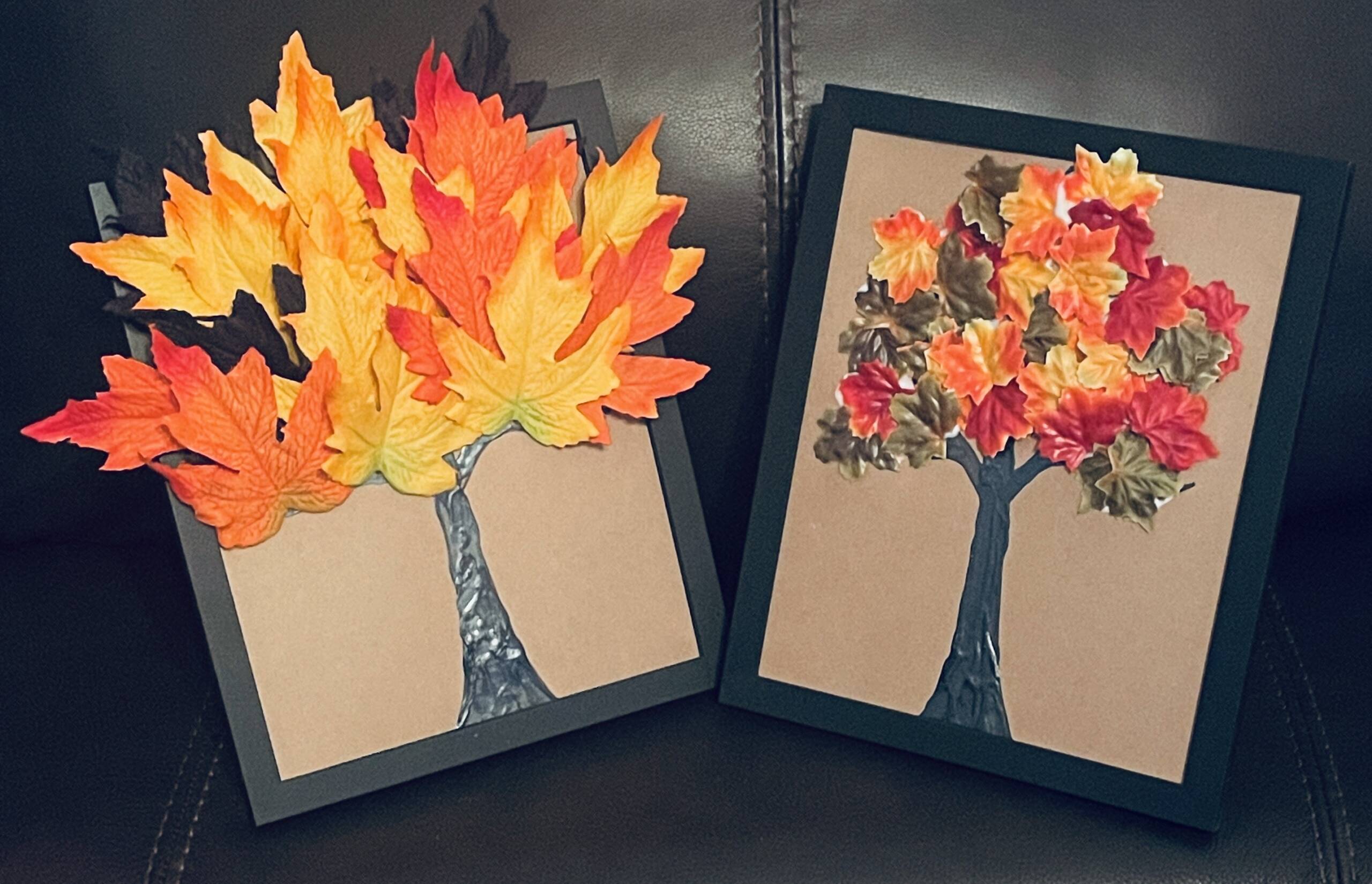 Two completed trees craft with plastic autumn leaves.