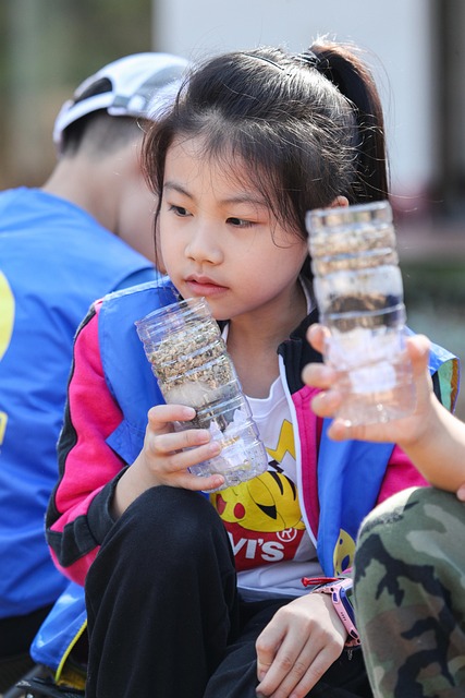 Girl outside in a group collecting soil samples.