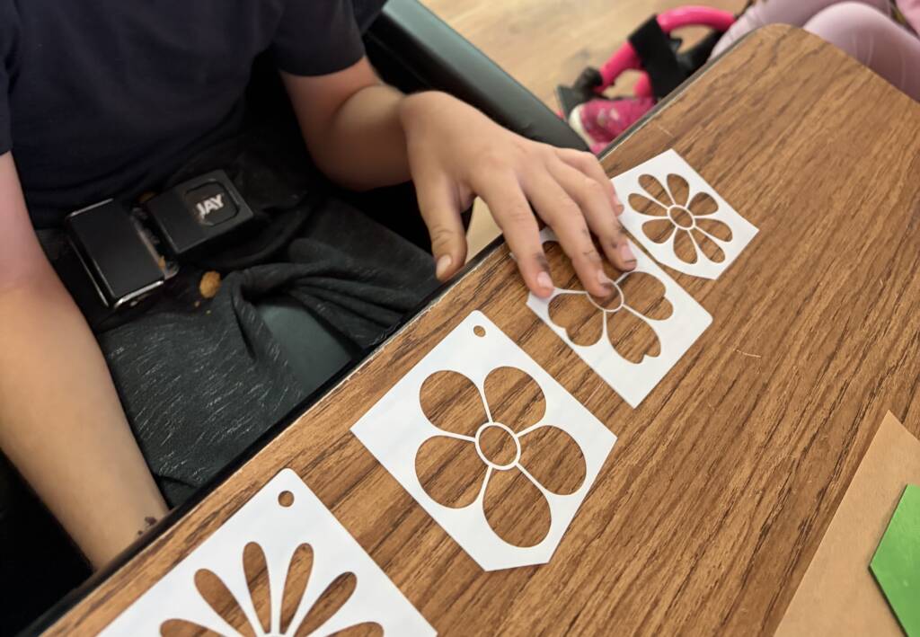 Student choosing a flower stencil from 4 choices.