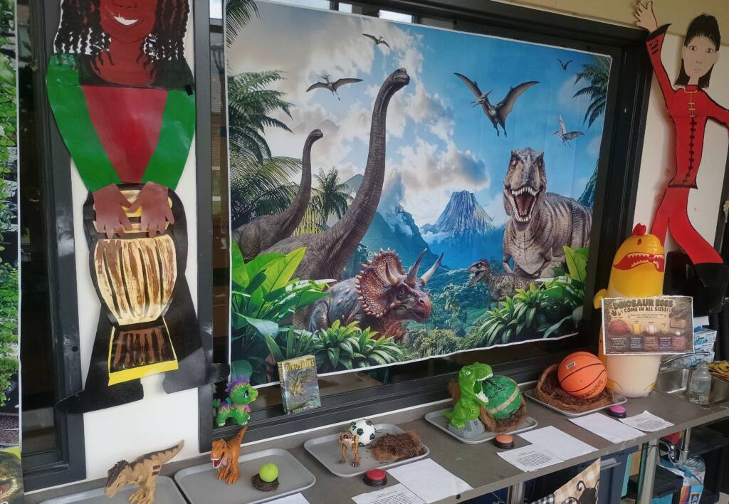 Dinosaur comparing station with 5 different dinos and their eggs, and information about each that includes a small AAC switch button.