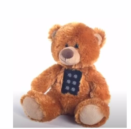 Soft teddy bear that has the 6 dots at his tummy to represent a braille cell.
