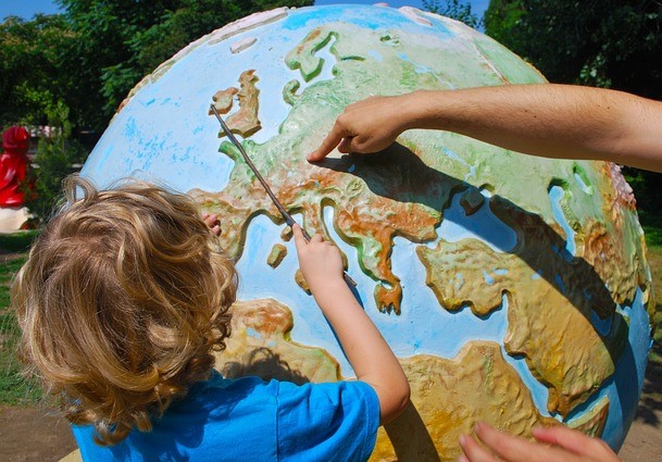 Two students touching a tactile globe.