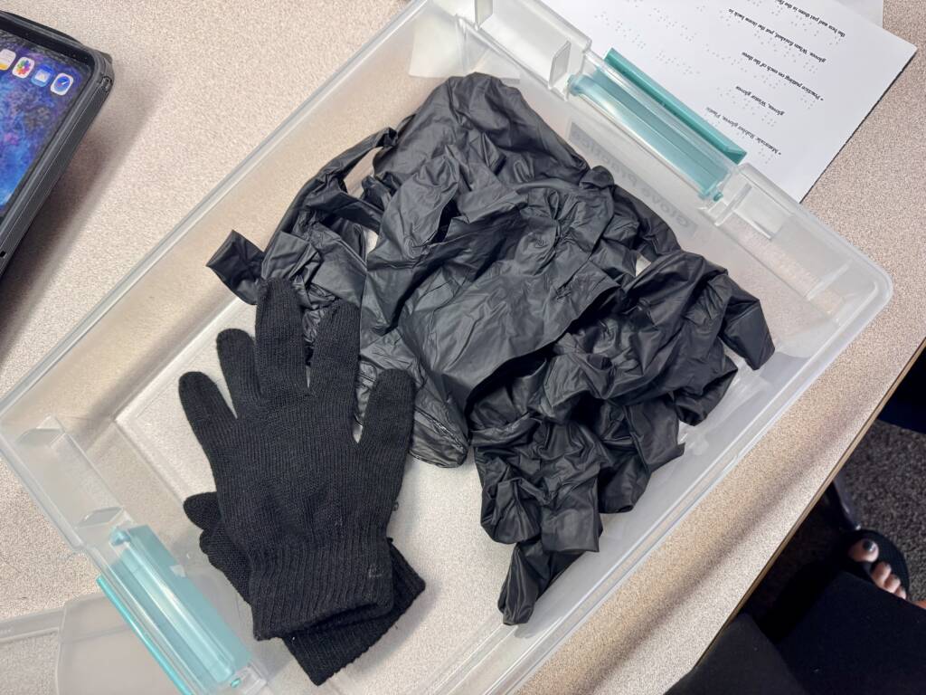Inside of glove practice box has winter gloves and several disposable gloves, rubber and plastic.