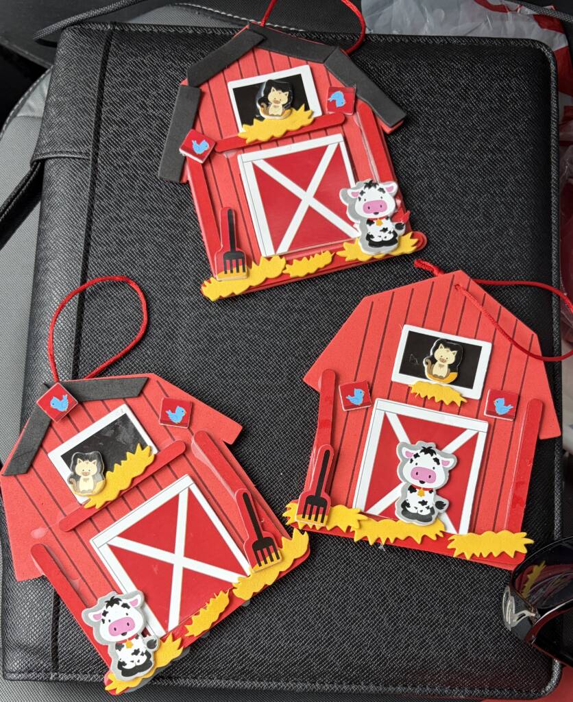 Three ornament barn crafts with a red barn and a cow and cat on each.